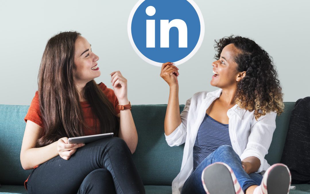 Two joyful and relaxed young girls sitting on a green sofa, both looking up at a large LinkedIn logo